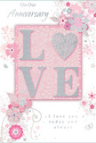 This anniversary card appears as a gentle celebration of enduring romance, akin to a carefully selected gift from a Bow florist after wandering through the paths of Mile End Park. Its colour scheme blends soft pastel pinks with cool silvery greys, creating an atmosphere of treasured intimacy and calm. At the centre of the design, the word LOVE is spelled out in raised, softly shimmering glitter, with the letter O replaced by a textured, silver-toned heart that catches the light like a tiny piece of jewellery. This heart sits snugly within the other letters, symbolising a bond that holds everything together. Around this central word, delicate blooms in blush and mauve unfurl across the card with a watercolor softness, their petals defined by fine, flowing lines that suggest both lightness and careful artistry, much like a florist shaping a romantic bouquet for a home near Bow Church. Tiny flourishes-small petals, swirling curls, and discreet butterfly silhouettes-add a sense of motion, recalling the gentle rustle of flowers in a spring garden off Victoria Park's canal paths. The background stays softly tinted, allowing the florals and glittering word to remain the focal point without distraction. Elegantly scripted text reads On Our Anniversary and I love you today and always, the lettering poised and restrained, echoing genuine warmth rather than dramatic sentiment. Overall, the composition feels like a whispered promise preserved on card stock, a keepsake that quietly honours years of shared life in Bow and beyond, as tender and enduring as a favourite bouquet revisited year after year.